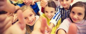 group of school kids showing thumbs up