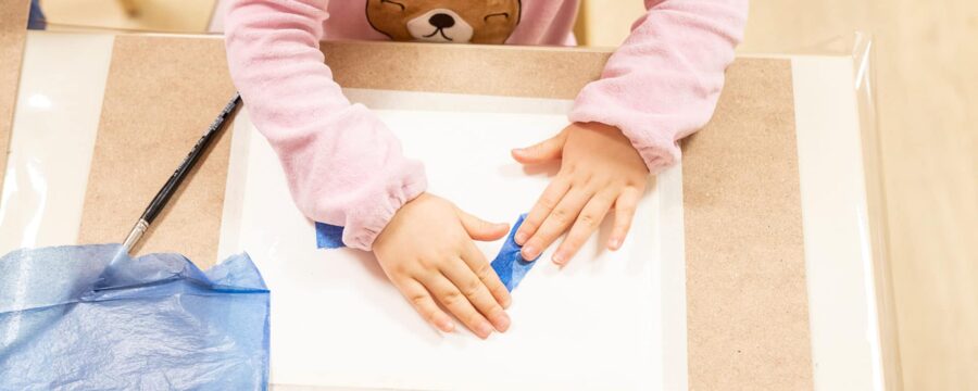 child's hands on a desk